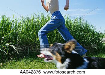 Stock Photo - boy (8-10) running 
with dog, low 
section, side 
view. fotosearch 
- search stock 
photos, pictures, 
images, and photo 
clipart