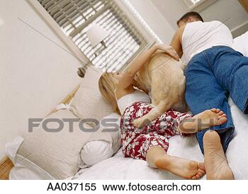 Stock Image - couple lying on 
bed with a dog. 
fotosearch - search 
stock photos, 
pictures, images, 
and photo clipart