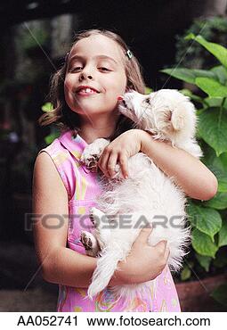 Stock Photography - girl (6-8) holding 
dog, dog licking 
girl's face (selective 
focus). fotosearch 
- search stock 
photos, pictures, 
images, and photo 
clipart