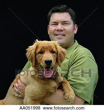 Stock Photo - man holding golden 
retriever puppy, 
high section. 
fotosearch - search 
stock photos, 
pictures, images, 
and photo clipart