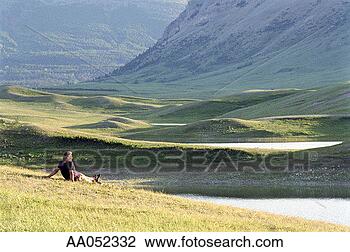 Stock Photo - canada, alberta, 
waterton lakes, 
man sitting on 
grass, rear view. 
fotosearch - search 
stock photos, 
pictures, images, 
and photo clipart