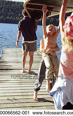 Stock Photography - father and three 
children (5-9) 
carrying canoe 
to end of dock. 
fotosearch - search 
stock photos, 
pictures, images, 
and photo clipart