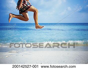 Stock Photography - man on beach leaping 
in the air, low 
section. fotosearch 
- search stock 
photos, pictures, 
images, and photo 
clipart