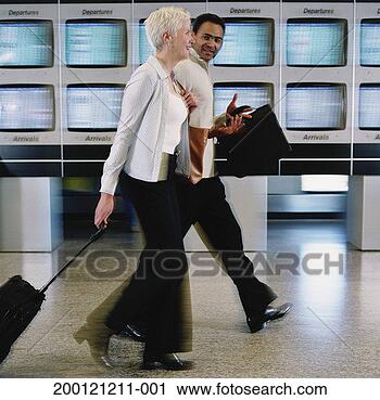 Stock Photography - man and woman 
walking through 
airport, side 
view (blurred 
motion). fotosearch 
- search stock 
photos, pictures, 
images, and photo 
clipart
