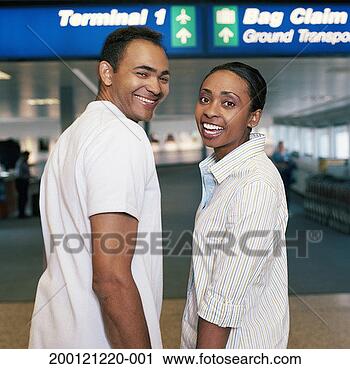 Stock Photography - man and woman 
walking through 
airport holding 
hands, portrait. 
fotosearch - search 
stock photos, 
pictures, images, 
and photo clipart