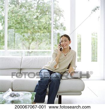 Arquivo de Fotografia - adolescente,  
menina,  sentando, 
 sofá,  falando, 
 móvel,  telefone. 
fotosearch - busca 
de fotos, imagens 
e clipart