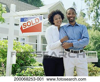 Stock Photography - couple standing 
in front of sold 
sign in front 
yard of house, 
portrait. fotosearch 
- search stock 
photos, pictures, 
images, and photo 
clipart