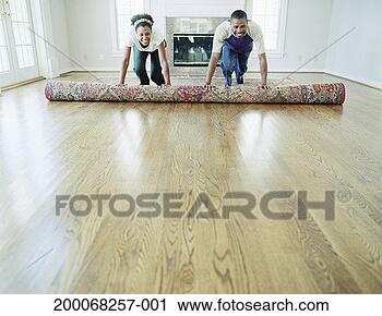 Stock Photography - couple unrolling 
area rug in living 
room of new home. 
fotosearch - search 
stock photos, 
pictures, images, 
and photo clipart