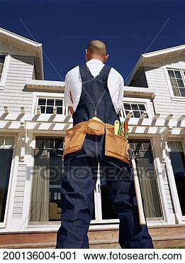 Stock Photography - man wearing overalls 
and tool belt 
looking at house, 
rear view. fotosearch 
- search stock 
photos, pictures, 
images, and photo 
clipart