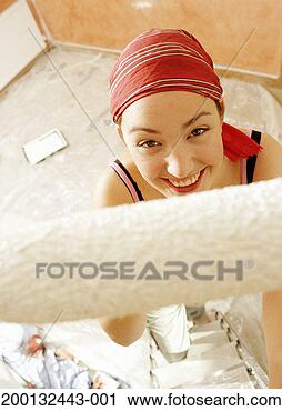 Stock Photography - woman on step 
ladder holding 
paint roller, 
portrait, elevated 
view. fotosearch 
- search stock 
photos, pictures, 
images, and photo 
clipart