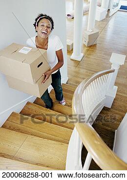 Stock Photography - young woman carrying 
boxes up staircase 
of new home, elevated 
view. fotosearch 
- search stock 
photos, pictures, 
images, and photo 
clipart