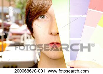 Stock Photography - young woman holding 
paint samples 
in front of face 
in hardware store. 
fotosearch - search 
stock photos, 
pictures, images, 
and photo clipart