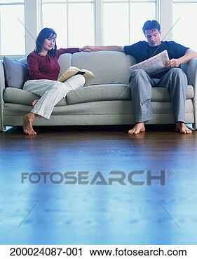 Stock Photography - couple reading 
together on sofa, 
low angle view. 
fotosearch - search 
stock photos, 
pictures, images, 
and photo clipart
