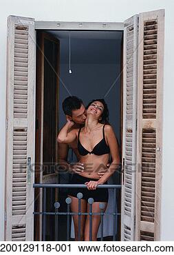 Stock Photography - woman in underwear 
being kissed by 
man on balcony. 
fotosearch - search 
stock photos, 
pictures, images, 
and photo clipart