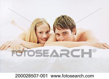Stock Photography - young couple lying 
on bed, portrait. 
fotosearch - search 
stock photos, 
pictures, images, 
and photo clipart