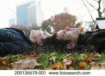 Stock Photography - young couple lying 
head to head on 
grass, side view. 
fotosearch - search 
stock photos, 
pictures, images, 
and photo clipart