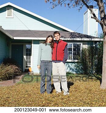 Stock Photography - young couple standing 
in front of home, 
portrait. fotosearch 
- search stock 
photos, pictures, 
images, and photo 
clipart