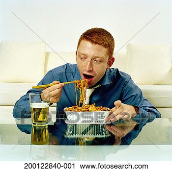 Stock Photography - young man eating 
noodles from takeaway 
container. fotosearch 
- search stock 
photos, pictures, 
images, and photo 
clipart