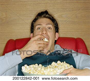 Stock Photography - young man eating 
popcorn, portrait, 
close-up. fotosearch 
- search stock 
photos, pictures, 
images, and photo 
clipart