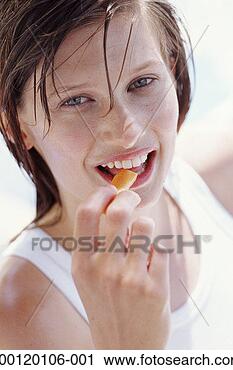 Stock Photography - young woman putting 
food in mouth 
outdoors, close-up, 
portrait. fotosearch 
- search stock 
photos, pictures, 
images, and photo 
clipart