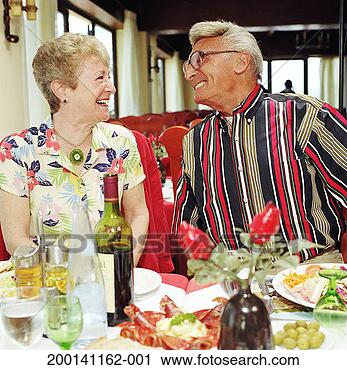 Stock Photography - couple at table 
with food and 
drinks, looking 
at each other, 
smiling. fotosearch 
- search stock 
photos, pictures, 
images, and photo 
clipart