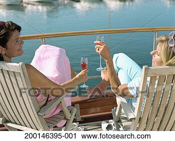 Stock Photography - two mature women 
relaxing on boat, 
holding drinks, 
rear view. fotosearch 
- search stock 
photos, pictures, 
images, and photo 
clipart