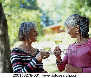 Stock Photography - two mature women 
drinking white 
wine, smiling 
at one another. 
fotosearch - search 
stock photos, 
pictures, images, 
and photo clipart