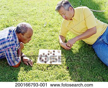 Stock Photography - two men playing 
drafts on grass, 
elevated view. 
fotosearch - search 
stock photos, 
pictures, images, 
and photo clipart