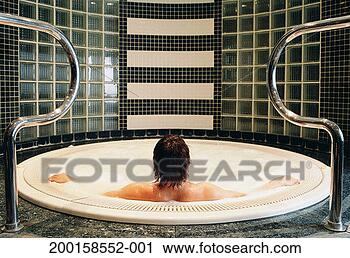 Stock Photography - young man sitting 
in whirlpool, 
arms outstretched, 
rear view. fotosearch 
- search stock 
photos, pictures, 
images, and photo 
clipart