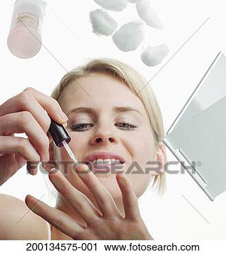 Stock Photography - young woman painting 
nails, low angle 
view. fotosearch 
- search stock 
photos, pictures, 
images, and photo 
clipart