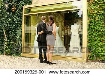 Stock Photography - couple embracing 
by shop window 
containing wedding 
dresses, rear 
view. fotosearch 
- search stock 
photos, pictures, 
images, and photo 
clipart