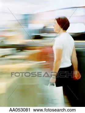 Stock Photography - woman carrying 
shopping bag through 
retail store (blurred 
motion). fotosearch 
- search stock 
photos, pictures, 
images, and photo 
clipart