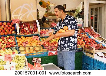 Stock Photography - young man selecting 
oranges outside 
greengrocers. 
fotosearch - search 
stock photos, 
pictures, images, 
and photo clipart