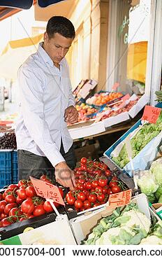Stock Photography - young man selecting 
tomatoes outside 
greengrocers. 
fotosearch - search 
stock photos, 
pictures, images, 
and photo clipart