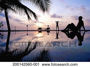 Stock Photography - man sitting at 
side of outdoor 
pool, watching 
woman at other 
end, dusk. fotosearch 
- search stock 
photos, pictures, 
images, and photo 
clipart