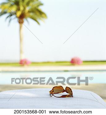 Stock Photography - sun glasses sitting 
near pool. fotosearch 
- search stock 
photos, pictures, 
images, and photo 
clipart