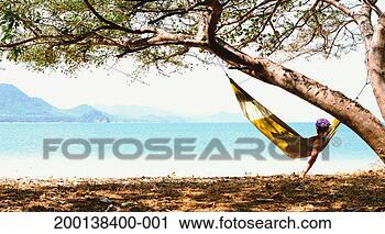 Stock Photography - thailand, krabi, 
young woman in 
hammock looking 
out to sea. fotosearch 
- search stock 
photos, pictures, 
images, and photo 
clipart