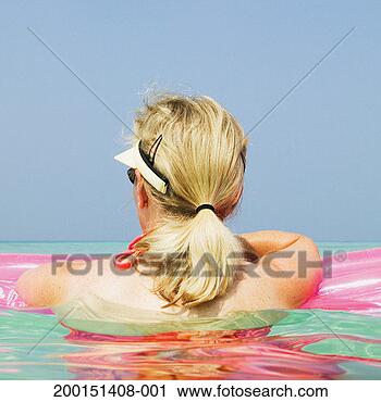 Stock Photography - woman holding 
onto float in 
ocean, rear view. 
fotosearch - search 
stock photos, 
pictures, images, 
and photo clipart