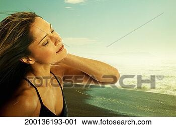 Stock Photography - young woman standing 
on beach, close-up 
(digital composite). 
fotosearch - search 
stock photos, 
pictures, images, 
and photo clipart