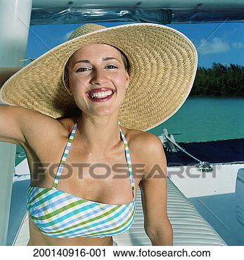 Stock Photography - young woman in 
straw hat sitting 
on boat, portrait. 
fotosearch - search 
stock photos, 
pictures, images, 
and photo clipart
