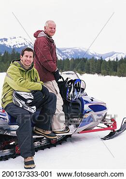 Stock Photography - father and adult 
son on snowmobile, 
smiling, portrait. 
fotosearch - search 
stock photos, 
pictures, images, 
and photo clipart