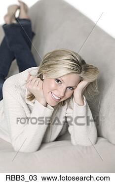 Stock Photo - a young blonde 
caucasian woman 
lays on a couch 
and smiles. fotosearch 
- search stock 
photos, pictures, 
images, and photo 
clipart