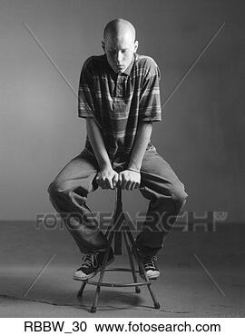 Stock Photography - a full body portrait 
of a bald caucasian 
man who sits on 
a stool. fotosearch 
- search stock 
photos, pictures, 
images, and photo 
clipart
