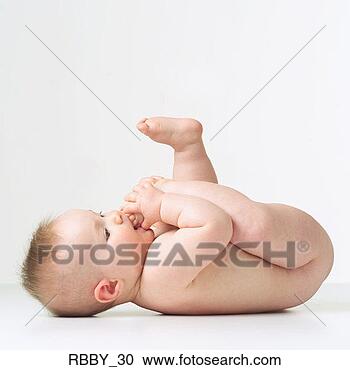 Stock Photography - a caucasian baby 
lies naked on 
its back and puts 
its foot in its 
mouth. fotosearch 
- search stock 
photos, pictures, 
images, and photo 
clipart