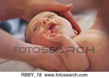 Stock Photo - a newborn caucasian 
baby lies naked 
as a mother caresses 
it. fotosearch 
- search stock 
photos, pictures, 
images, and photo 
clipart