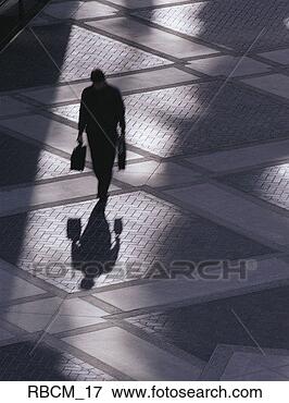 Picture - a business man 
walks along a 
side walk while 
carrying a brief 
case. fotosearch 
- search stock 
photos, pictures, 
images, and photo 
clipart