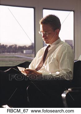 Picture - a businessman 
dressed in a white 
shirt and black 
slacks reads a. 
fotosearch - search 
stock photos, 
pictures, images, 
and photo clipart