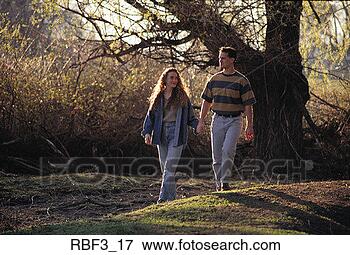 Picture - a brunette woman 
wearing jeans 
walks hand in 
hand with a man 
wearing. fotosearch 
- search stock 
photos, pictures, 
images, and photo 
clipart