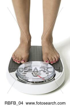 Stock Photo - close-up of a 
woman's feet as 
she stands on 
scale to weigh 
herself. fotosearch 
- search stock 
photos, pictures, 
images, and photo 
clipart