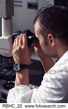 Stock Photo - a male medical 
lab technician 
looks through 
a microscope and 
studies. fotosearch 
- search stock 
photos, pictures, 
images, and photo 
clipart